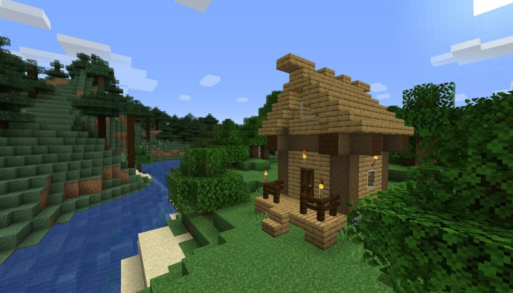Minecraft Spiel: Beispiel für ein einfaches Holzhaus neben einem Fluss im Minecraft-Spiel.