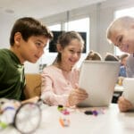 Kinder mit Tablet-PC-Programmierung in der Robotikschule
