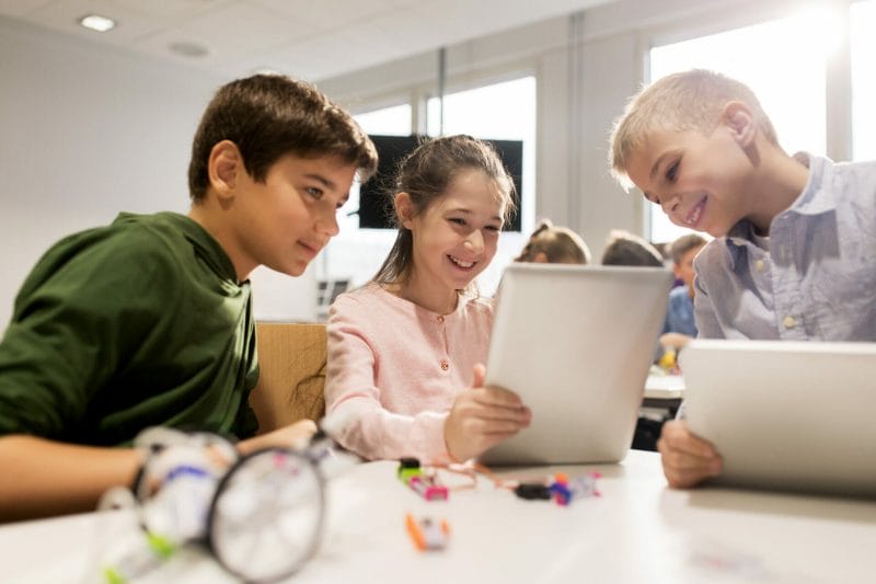 Kinder mit Tablet-PC-Programmierung in der Robotikschule