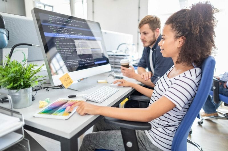 Pair-Programming mit einem codora CodeMentor am Computer.
