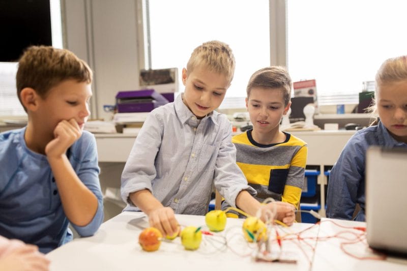 Kinder führen ein Experiment mit einem Mikrocontroller und Zitronen durch.