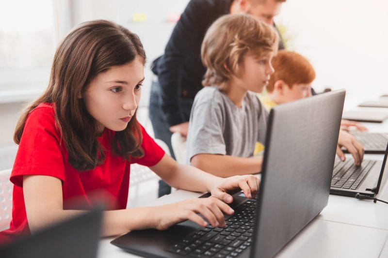 Ein Mädchen löst fokussiert spannende Programmierrätsel.