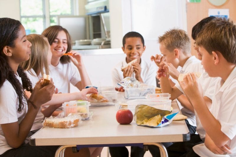 Eine Gruppe Kinder und Teenager verbringen eine unterhaltsame Mittagspause zusammen.